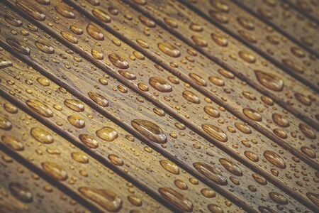 Water drops pattern on wooden floor. Tinted colors, matte filter. Shallow depth of field.の写真素材