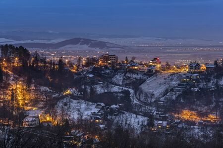 Cold winter nightfall over the surrounding hills of Brasov city, Romania.
