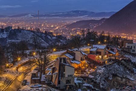 Night wintry cityscape with city lights of Brasov city, Romania.の写真素材