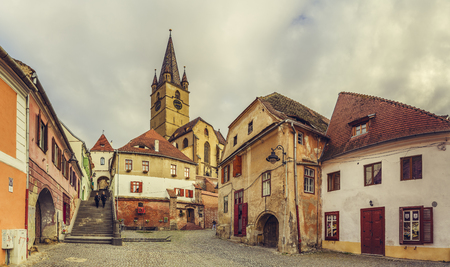 SIBIU, ROMANIA - 11 NOVEMBER, 2015: The 73.34 m high steeple of the Evangelic Church, built in 1530 in the Huet Square, as seen from the streets of medieval Lower Town of Sibiu city, Romania.のeditorial素材