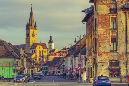 SIBIU, ROMANIA - 12 NOVEMBER, 2015: The Evangelic Church in the warm sunset light. Raised in 1530 in the Huet Square, it is the most impressive building of the city with its 73.34 m high steeple.のeditorial素材