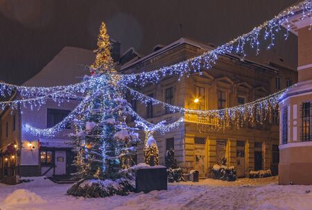 BRASOV, ROMANIA - 6 JANUARY, 2015: Winter night cityscape with traditional Christmas tree and decorative lights in George Enescu square in the historic center of Brasov city.のeditorial素材