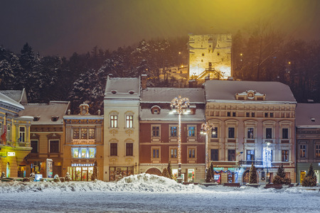 BRASOV, ROMANIA - 6 JANUARY, 2015: Winter night cityscape with snowy Council Square in the historic center of Brasov city on Christmas holidays.のeditorial素材