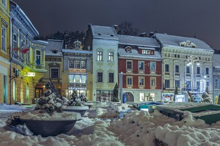 BRASOV, ROMANIA - 6 JANUARY, 2015: Winter nightfall city view with snowy Council Square in the historic center of Brasov city on Christmas holidays.のeditorial素材