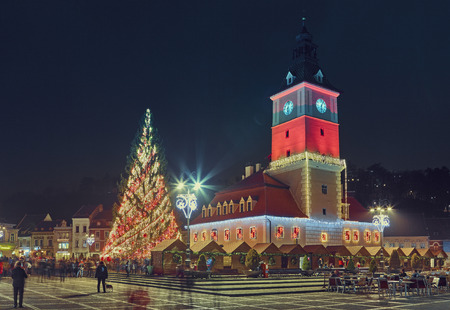 BRASOV, ROMANIA - 10 DECEMBER, 2015: Night scene in the Council Square with Christmas tree and traditional fair near the old City Hall building decorated and illuminated for Christmas holiday.のeditorial素材