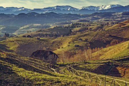 Picturesque spring rural scenery with traditional Romanian wooden house and country road uphill in Sirnea village, Brasov county, Romania. Travel destinations.の写真素材