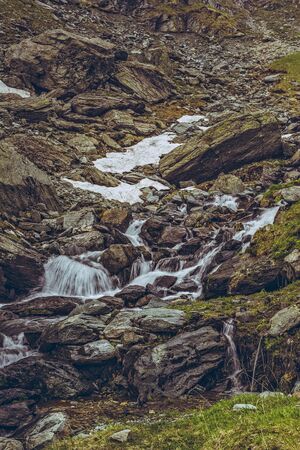 Mountain stream rapids flowing down among rocks nearby the famous Transfagarasan road in Fagaras mountains, Romania. Long exposure motion blur.の写真素材