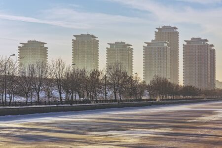 Picturesque morning scenery with modern high rise block of flats near frozen Dambovita river, in south-eastern Bucharest, Romania. High rise apartment blocks, tower blocks, real estate development.の写真素材