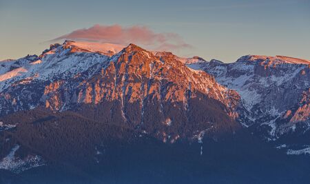 Majestic view with sunset light on the snowy Bucegi mount peaks, Carpathians mountains range, Romania. Picturesque hiking destinations. Romanian mountaineering attractions.の写真素材