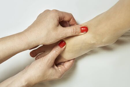 Close-up with Caucasian female foot receiving relaxing massage in therapy salon. Physical stress...