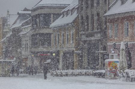 Brasov, Romania - 20 April, 2017: City life in the historic center of Brasov city during a heavy...