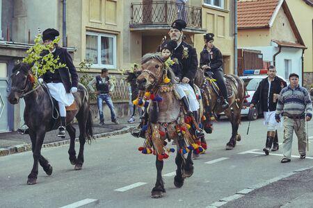 Brasov, Romania - April 27, 2014: Horsemen ride thoroughbred stallions adorned with traditional decorations during the Youths of Brasov (Junii Brasovului) Parade.のeditorial素材