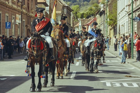 Brasov, Romania - April 27, 2014: Horsemen ride thoroughbred stallions adorned with traditional decorations during the Traditional Parade of the Youths of Brasov.のeditorial素材