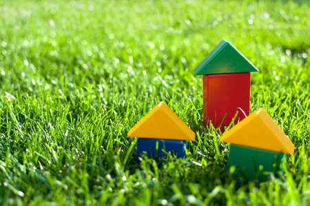 Three colored houses with blocks of green grass の写真素材