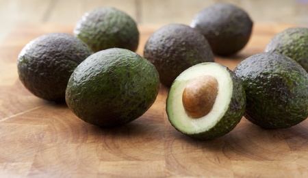 Avocados on a wooden chopping boradの写真素材