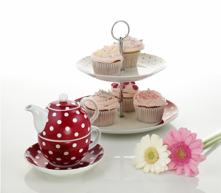 Cup cakes and tea pot on isolated white backgroundの写真素材