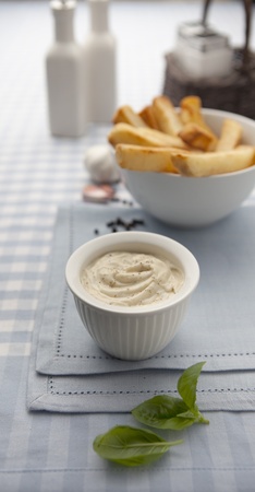 Creamy mayonaise in white china pot served with friesの写真素材