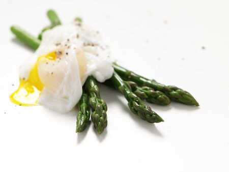 Asparagus with poached egg on isolated white backgroundの写真素材