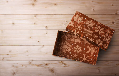 open Christmas gift box on a wooden background