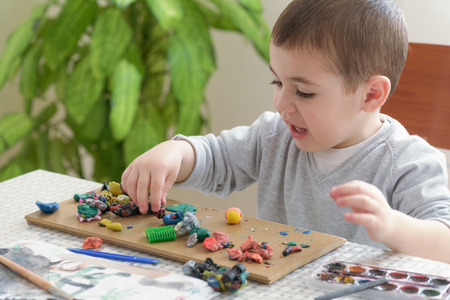 Little boy playing with clay, sculpting figures.の写真素材