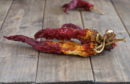 dry red peppers on a wooden tableの写真素材