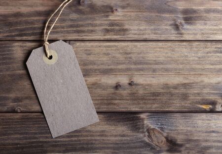 Blank price tag on the background of wooden planks