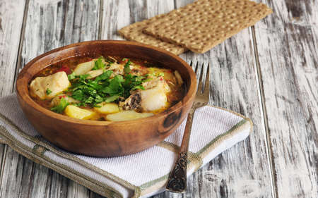 dish with chicken in a wooden bowl on the old tableの写真素材