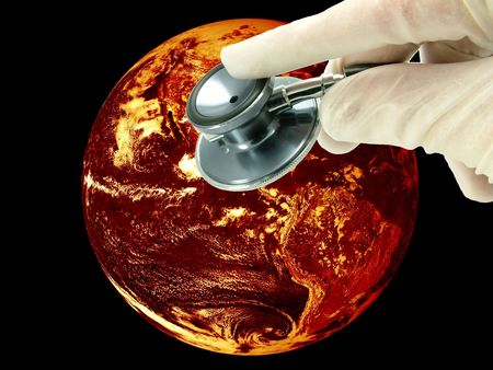 Global warming climate change concept. A health check of planet earth. The world is overheating due to climate change and shown in a fiery red and orange volcanic glow, with the hand of a Doctor and stethoscope.の写真素材