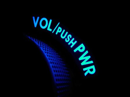 Cyan and blue neon lights glow in a dark blue haze on a power and volume handle.の写真素材