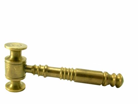 A brass judges gavel over white background.の写真素材