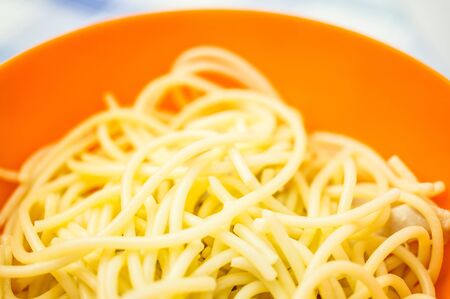 Pasta with chicken in an orange bowlの写真素材
