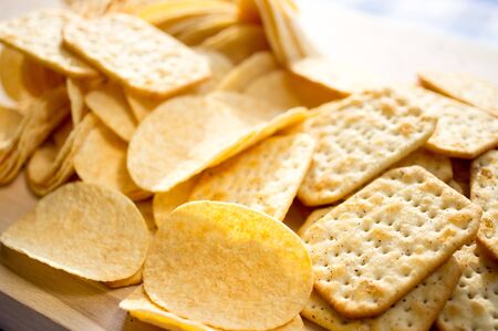 Chips and crackers scattered on the tableの写真素材