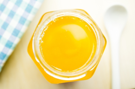 Honey in a glass jar with a spoonの写真素材