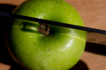 Knife cuts green ripe appleの写真素材
