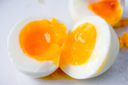 Two soft boiled eggs broken in half