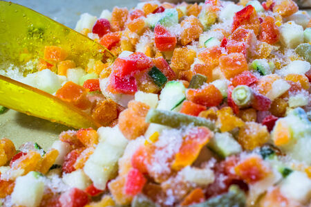 Frozen vegetables closeup colorful in hoarfrost. Packaging scoopの写真素材