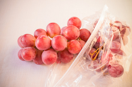 Grapes in a plastic bag on a white backgroundの写真素材