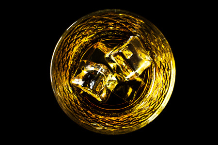 Bourbon whiskey with ice on a black backgroundの写真素材