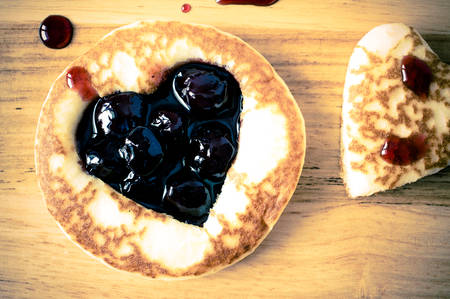 Pancakes in the form of hearts with cherry jam