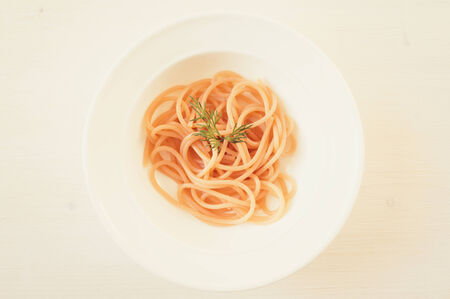 Pasta spaghetti in a white plate on a white table top viewの写真素材