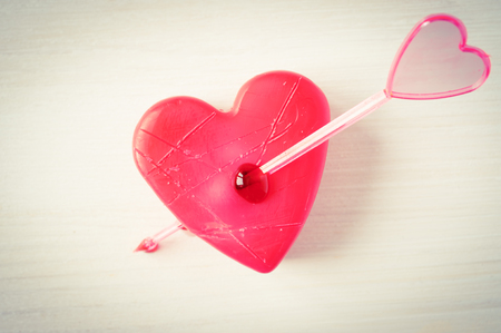 Concept wounded, broken heart pierced by an arrowの写真素材