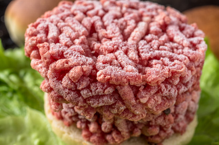 Frozen hamburger ground beef on lettuceの写真素材