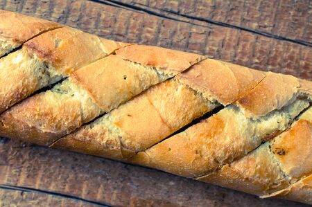 Baguette with spices on a wooden table. Top view