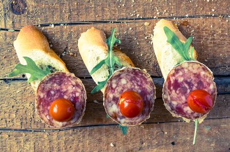 Spanish appetizer tapas, pintxos, pincho with arugula, cherry tomatoes and sausageの写真素材