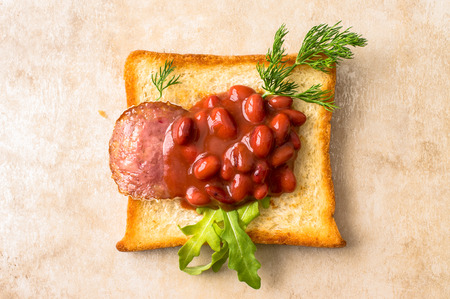 Tapas with grilled sausage and red beans on toastの写真素材