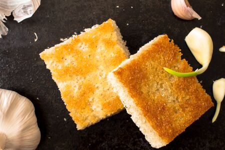 Grill tapas with garlic on a black background with the garlic cloves. Top viewの写真素材