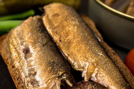 Tapas - large smoked sardines on a piece of black breadの写真素材