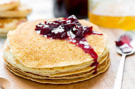 Cherry jam on a stack of pancakes Russian blini on the tableの写真素材