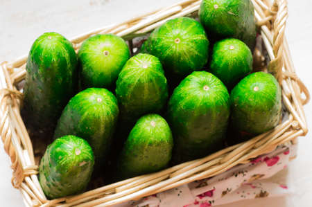 Fresh cucumbers are in the top view of a wicker basketの写真素材