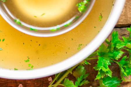 Closeup of broth in a saucepan and ladle and parsleyの写真素材